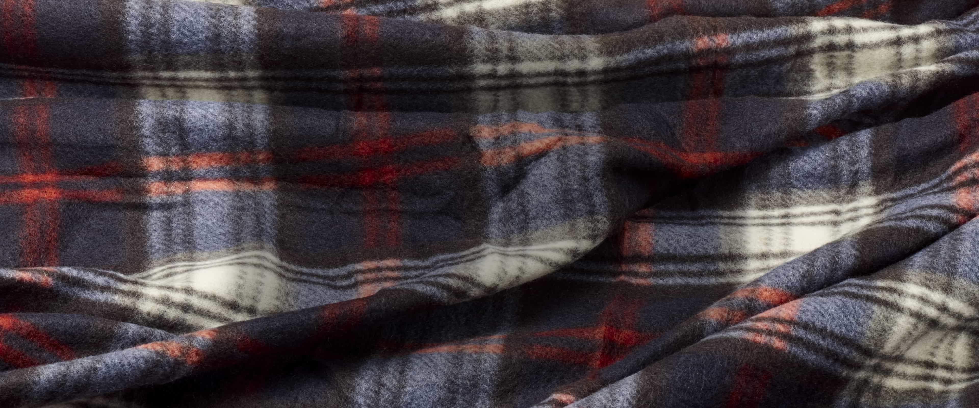 Buy more, save more featuring white text on a plaid blanket background.