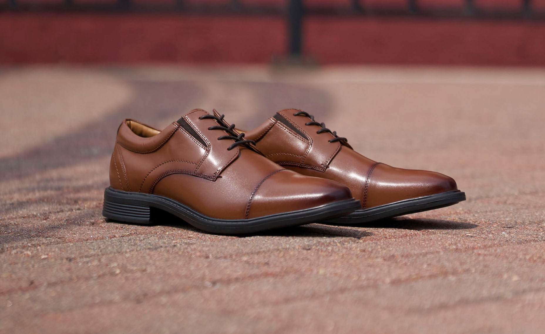 Shop Nunn Bush dress featuring the Jarvis cap toe in cognac on a brick street.